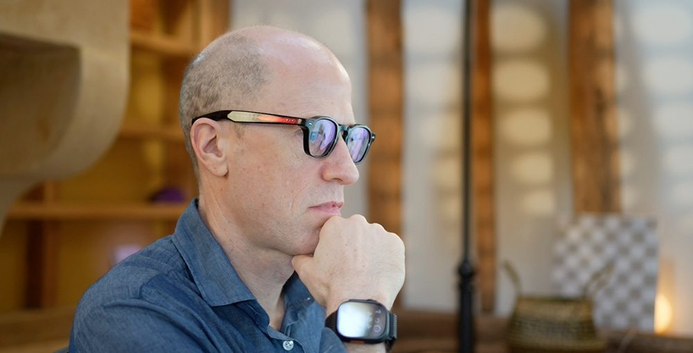 Indoors portrait of Nick Bostrom focusing and looking to the right